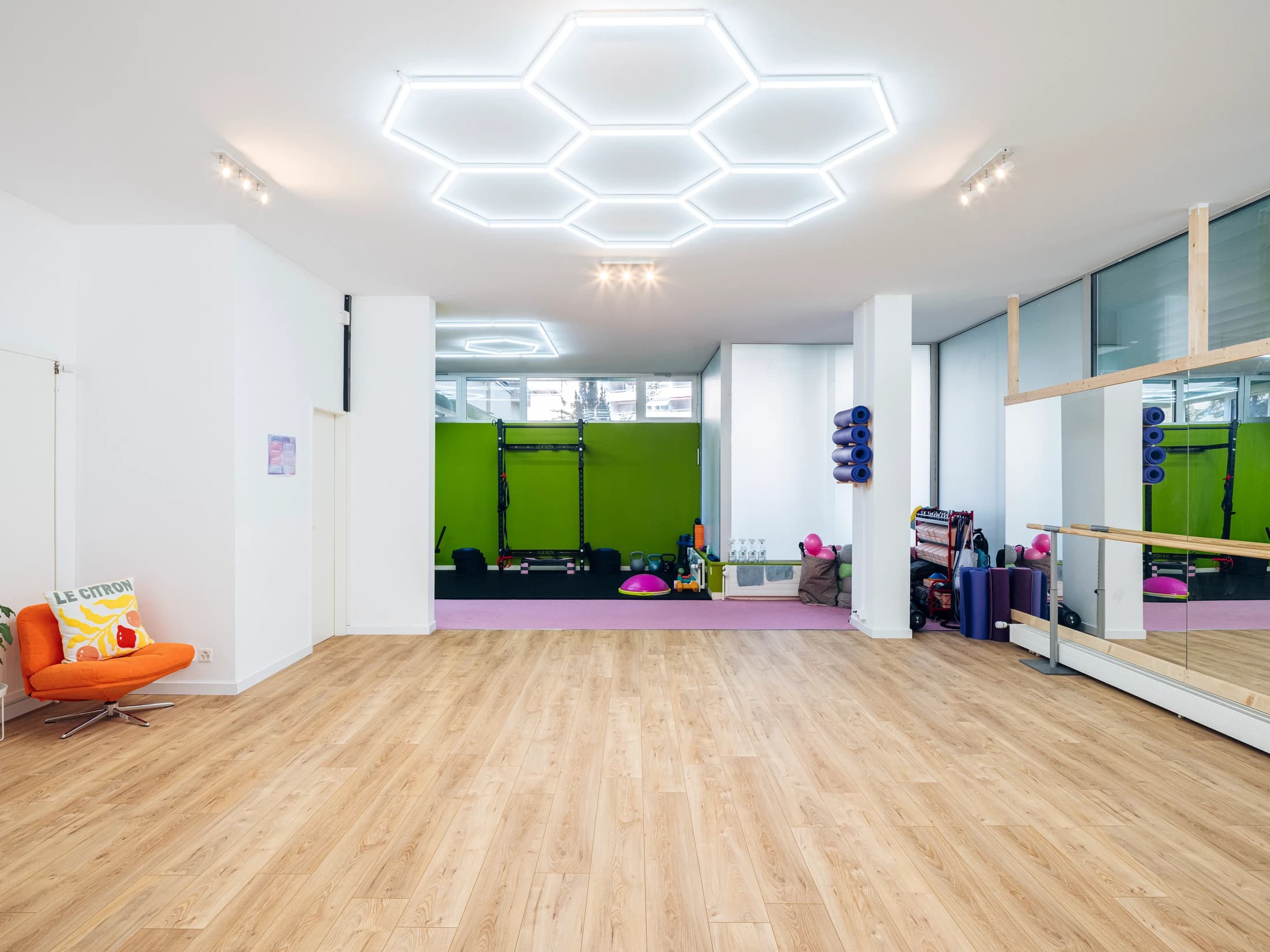 Grande salle de danse du studio COMOCO à Genève, mur citron et parquet bois
